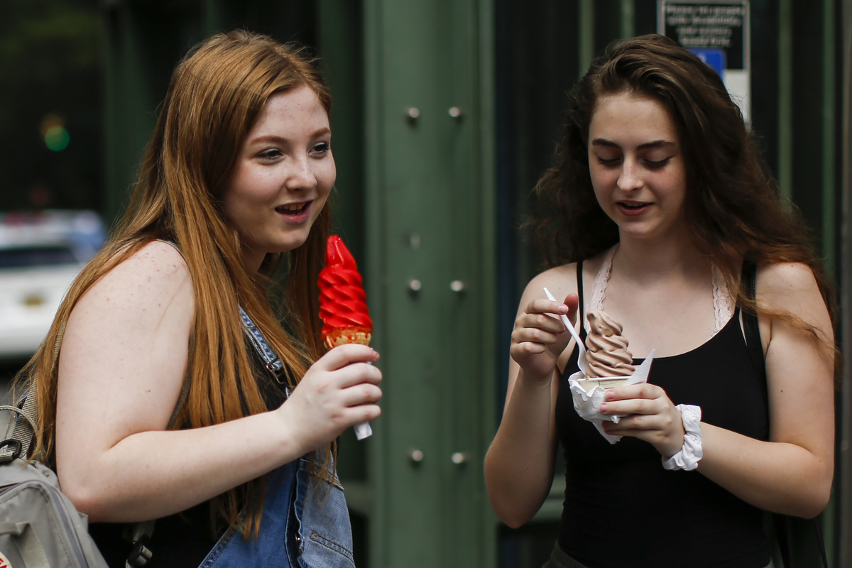 Two women eat ice cream cones in Central Park, New York.