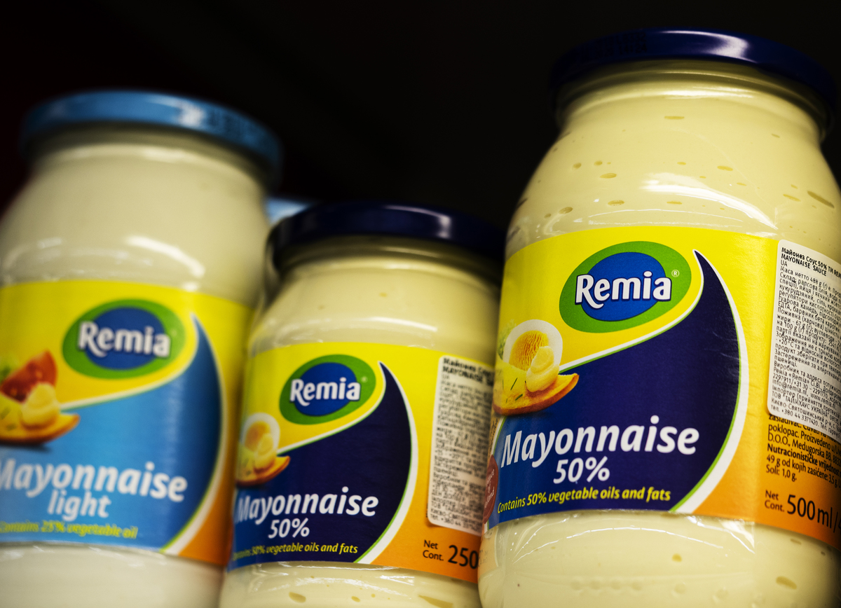 Jars of mayonnaise sit on a grocery store shelf.
