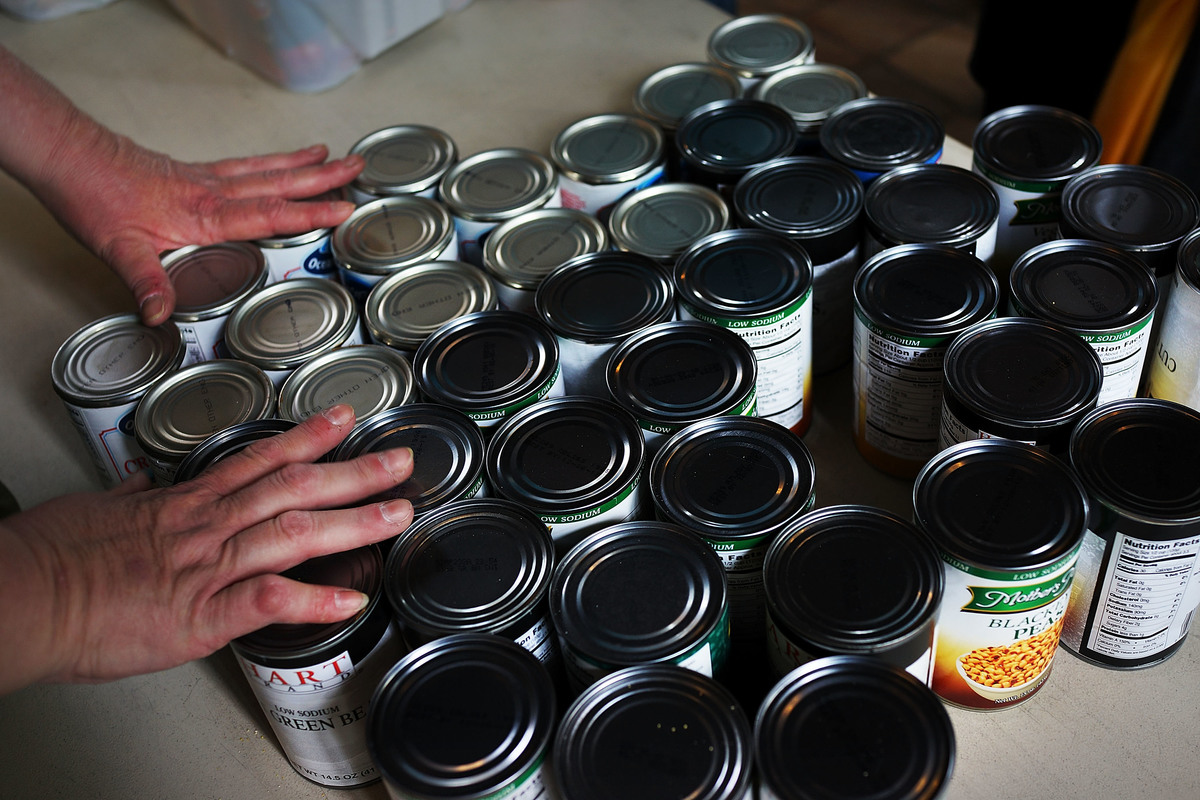 A volunteer organizes cans of soup for a soup kitchen.