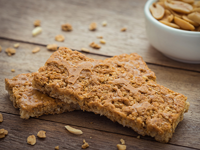 Granola bars on wooden table and peanuts.